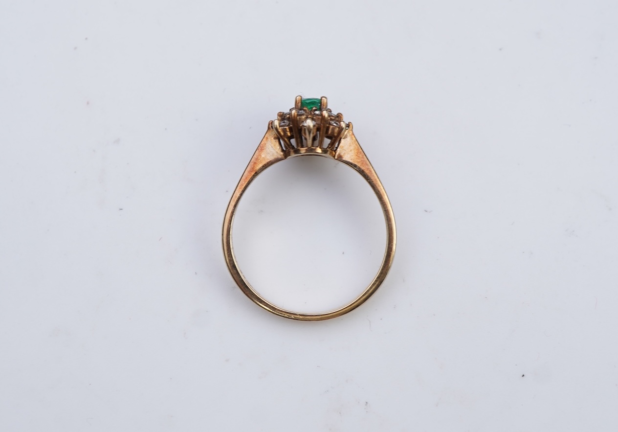 An emerald and diamond cluster ring